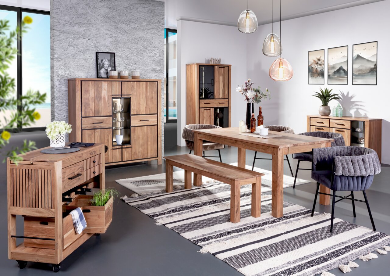 Landscape Servierwagen AKAZIO Esszimmer mit Holzmöbeln, darunter ein Esstisch, eine Bank, ein Servierwagen und ein Sideboard, aus der Perspektive von vorne links betrachtet.