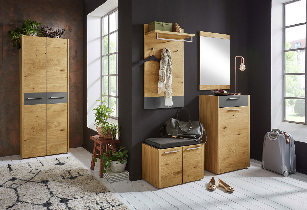 Moderner Eingangsbereich mit Sitzkissen auf einem Holzschrank, umgeben von Pflanzen und Dekorationen, seitliche Perspektive.