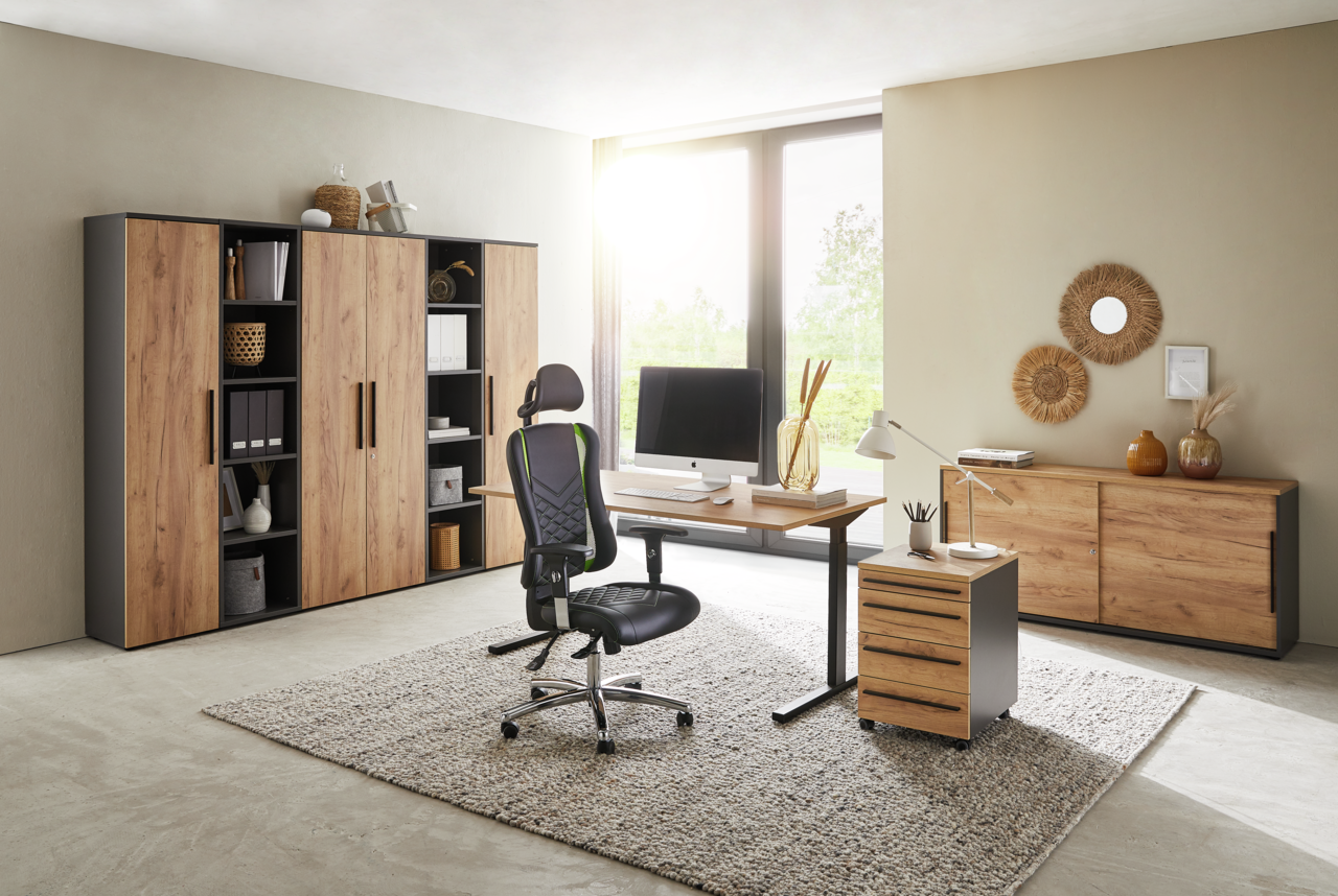 Moderne Büromöbel in einem hellen Raum mit Schreibtisch, Rollcontainer und Aktenschränken in Holzoptik, seitliche Perspektive.