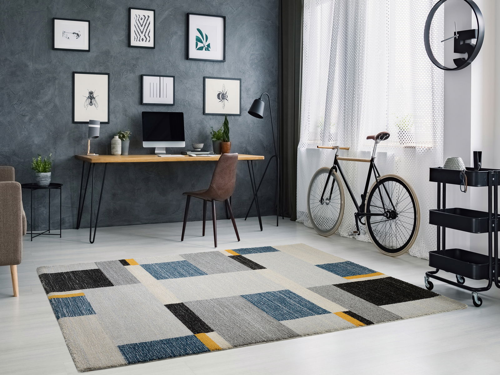 Moderner Teppich mit geometrischem Muster in einem stilvollen Arbeitszimmer, Perspektive von schräg oben.