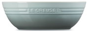 Hellblaue Le Creuset Keramikschüssel mit geprägtem Logo und Rillen, seitliche Frontansicht vor weißem Hintergrund