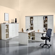 Moderner Eckschreibtisch in heller Holzoptik mit integriertem Stauraum, umgeben von passenden Schränken und einem Bürostuhl, aus der Perspektive eines Betrachters im Raum.