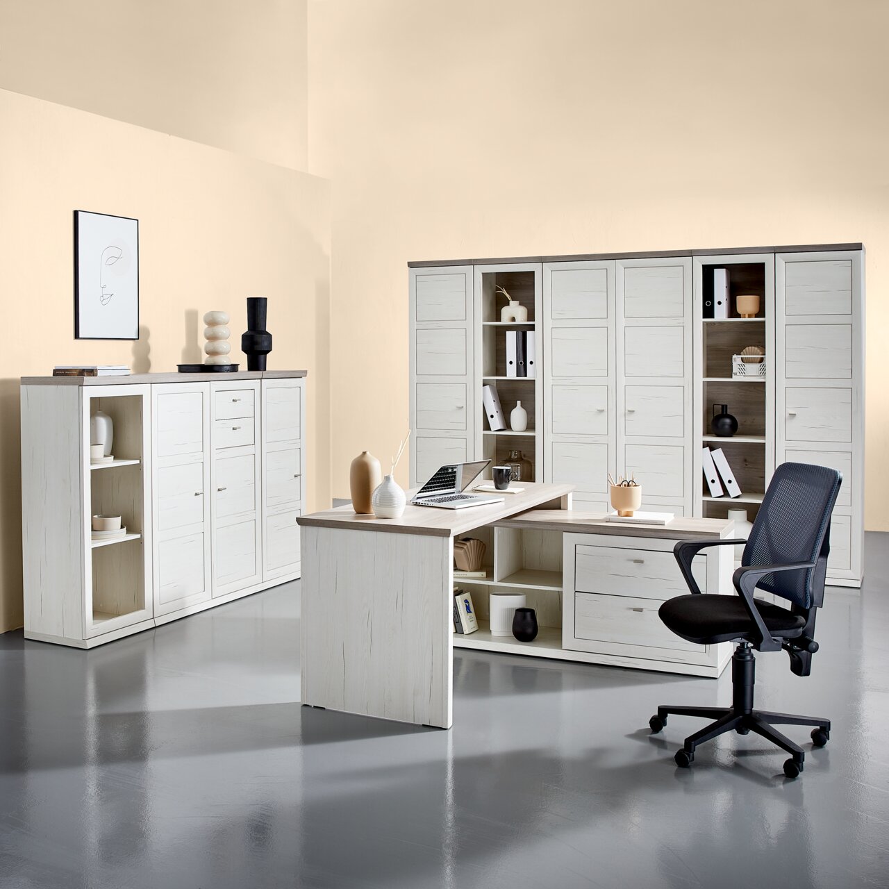 Moderner Eckschreibtisch in heller Holzoptik mit integriertem Stauraum, umgeben von passenden Schränken und einem Bürostuhl, aus der Perspektive eines Betrachters im Raum.