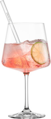 Nahaufnahme in frontaler Perspektive: bauchiges Weinglas mit rosafarbenem sprudelndem Drink, Eiswürfeln, Limettenscheibe und Glasstrohhalm auf weißem Hintergrund