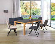 Moderner Esstisch aus Holz mit dunkler Tischplatte, umgeben von stilvollen Stühlen in einem hellen Raum mit großen Fenstern. Perspektive von schräg vorne.