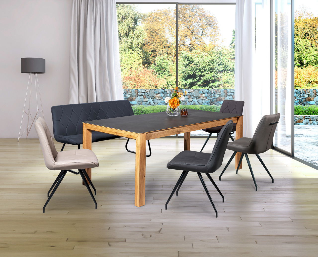 Moderner Esstisch aus Holz mit dunkler Tischplatte, umgeben von stilvollen Stühlen in einem hellen Raum mit großen Fenstern. Perspektive von schräg vorne.