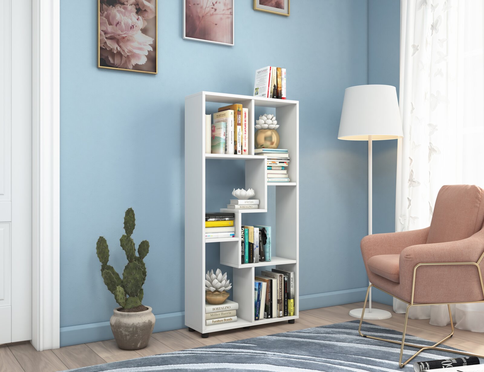 Modernes weißes Bücherregal mit asymmetrischen Fächern, mit Büchern und Deko in einem hellen Wohnzimmer neben Stehlampe und Sessel, frontal in leichter Seitenperspektive aufgenommen
