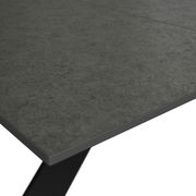 Nahaufnahme eines Gartentisches mit grauer Steinoptik-Oberfläche, perspektivisch von oben betrachtet.