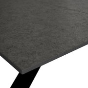 Close-up van een tuintafel met een grijs oppervlak in steenlook, in perspectief van bovenaf gezien.