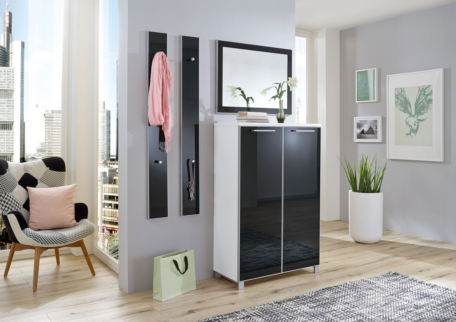 VOSS Schuhschrank SANTINA Moderner Eingangsbereich mit einem schwarzen Schuhschrank, zwei schmalen Garderobenpaneelen und einem großen Spiegel. Perspektive von vorne.