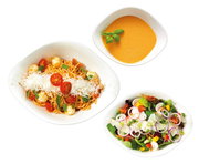 Draufsicht auf ein Starter-Set mit drei weißen Schalen, gefüllt mit Spaghetti mit Tomaten und Käse, einer cremigen Suppe und einem frischen Salat.
