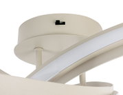 Close-up van een moderne led-plafondlamp met een gebogen vormgeving in crèmewit, gezien van onderaf.