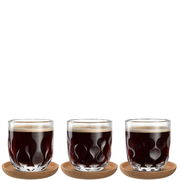 Drei Kaffeegläser mit wellenförmigem Design, gefüllt mit schwarzem Kaffee, auf runden Untersetzern, aus frontaler Perspektive.