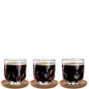 Drei Kaffeegläser mit wellenförmigem Design, gefüllt mit schwarzem Kaffee, auf runden Untersetzern, aus frontaler Perspektive.