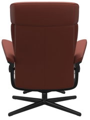 Achterkant van een bruine fauteuil met een zwart draaivoet