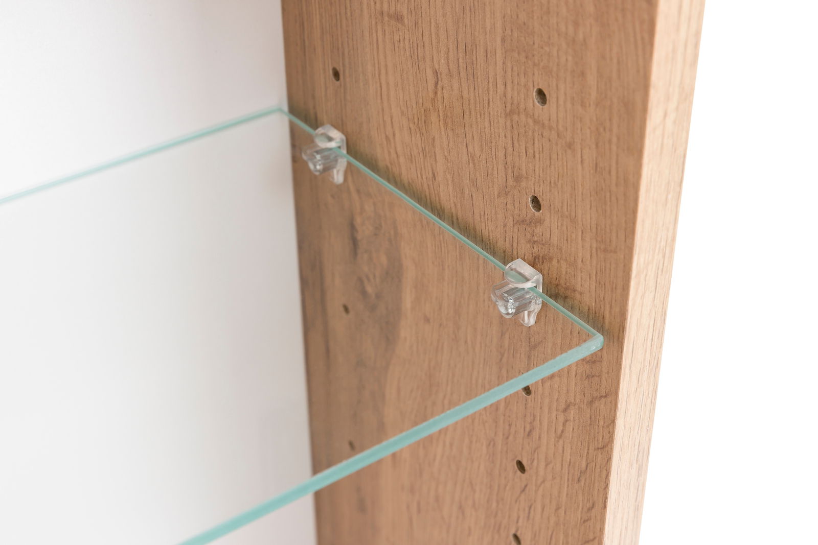 Nahaufnahme eines Spiegelschranks mit einem Glasregal, das an einer Holzwand befestigt ist. Perspektive von der Seite.