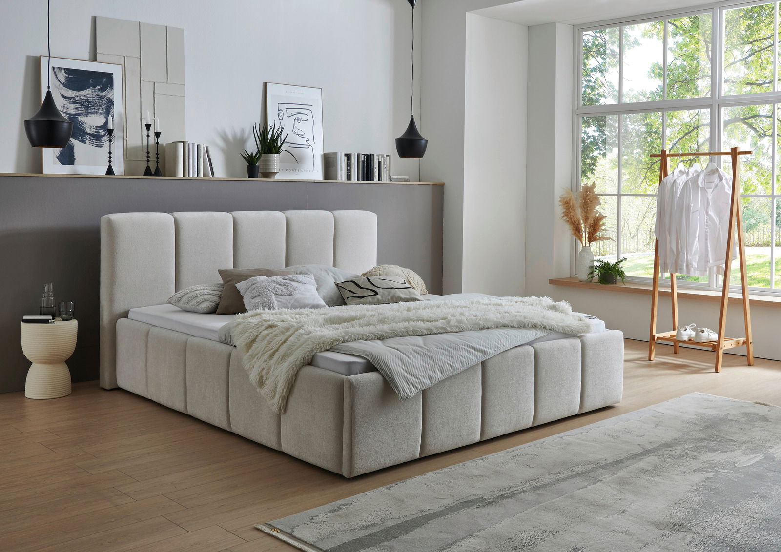 Modernes Polsterbett in einem stilvollen Schlafzimmer mit großen Fenstern, seitliche Perspektive