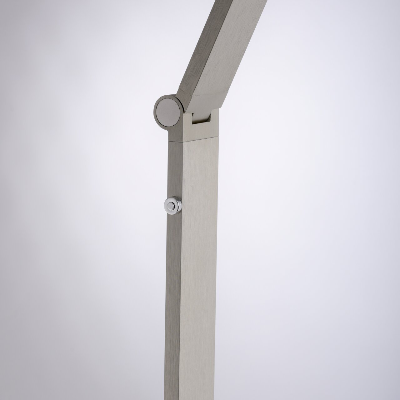 Detailansicht einer modernen LED-Stehleuchte mit verstellbarem Arm und silbernem Finish.