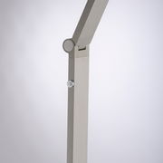 Detailansicht einer modernen LED-Stehleuchte mit verstellbarem Arm und silbernem Finish.