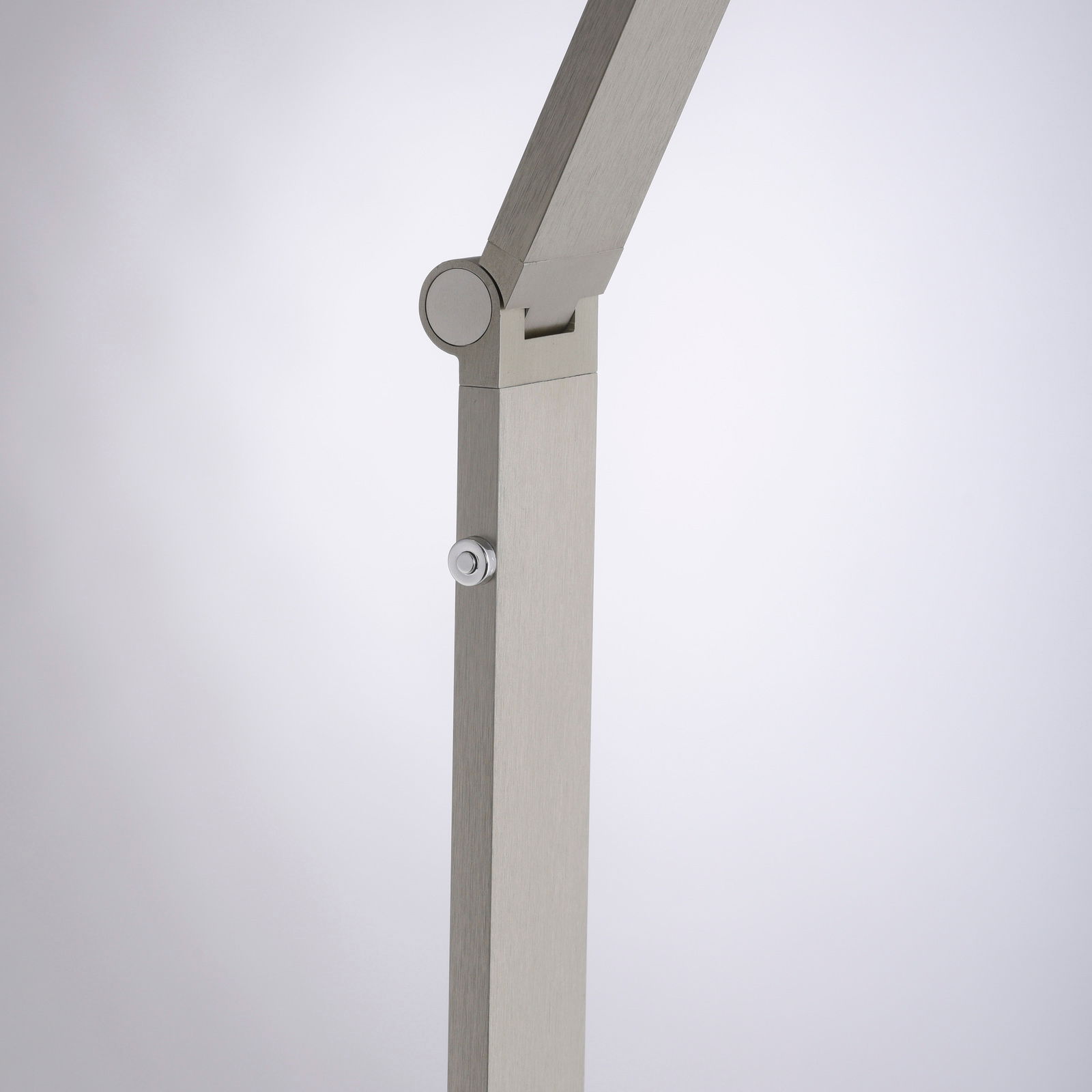 Detailansicht einer modernen LED-Stehleuchte mit verstellbarem Arm und silbernem Finish.