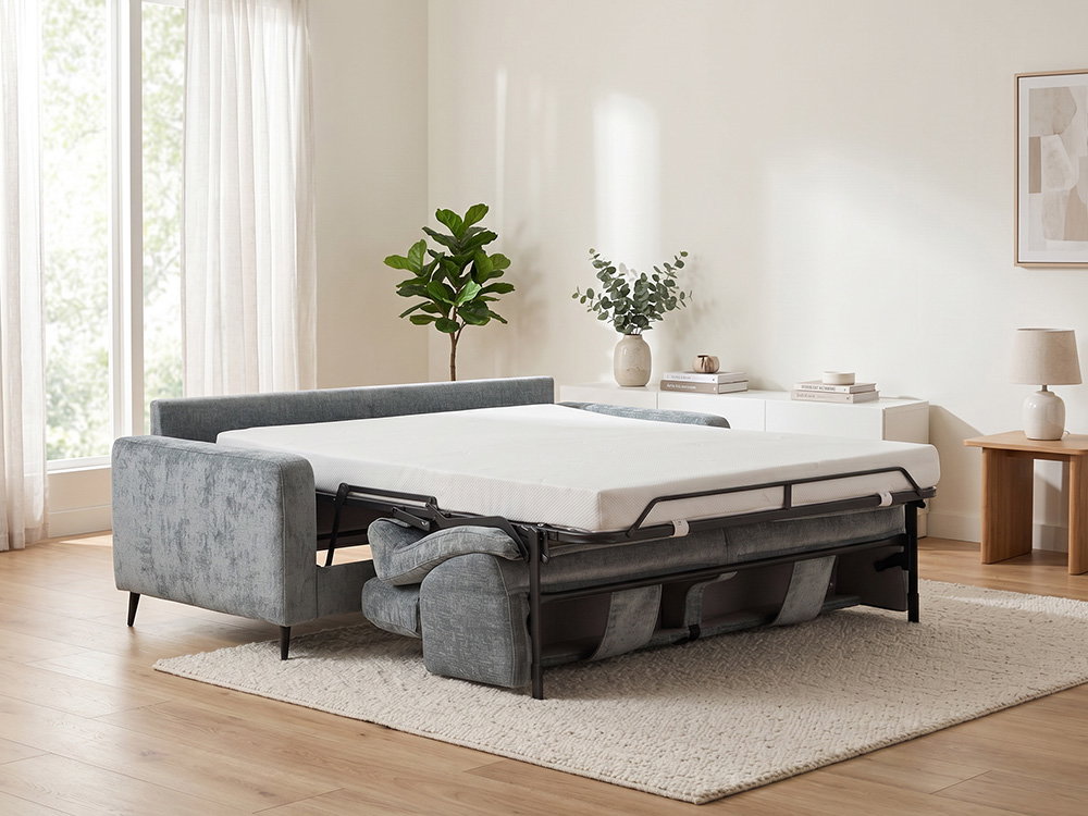 Grijze slaapbank uitgeklapt met matras in een lichte, moderne woonkamer.