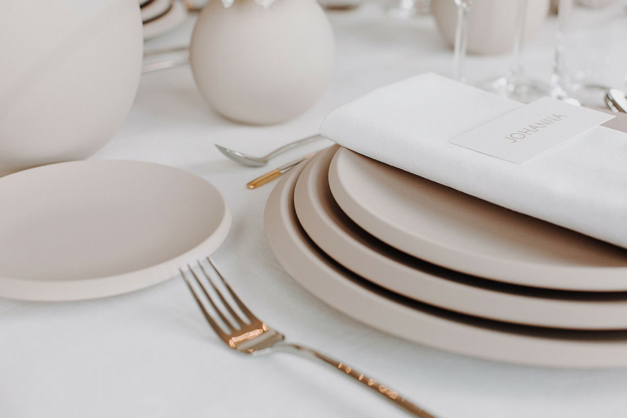 Eleganter Speiseteller NewMoon 27cm in einer stilvollen Tischdekoration, seitliche Perspektive.