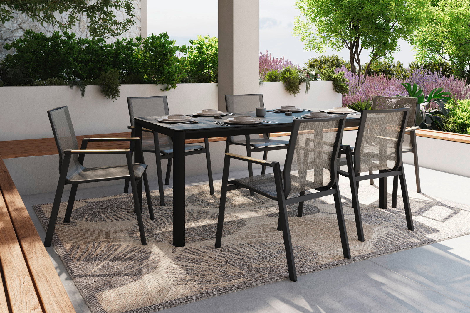 Moderner Stapelstuhl aus schwarzem Metall und Netzgewebe, aufgestellt auf einer Terrasse mit Tisch und Pflanzen im Hintergrund, seitliche Perspektive.