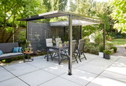 Moderne Pergola mit Faltdach und Sichtschutz, umgeben von Gartenmöbeln und Pflanzen, aus seitlicher Perspektive fotografiert.