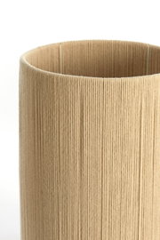 Nahaufnahme eines zylindrischen, beige-farbenen Lampenschirms mit texturierter Oberfläche.