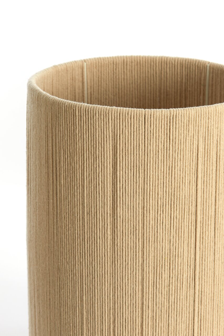 Nahaufnahme eines zylindrischen, beige-farbenen Lampenschirms mit texturierter Oberfläche.