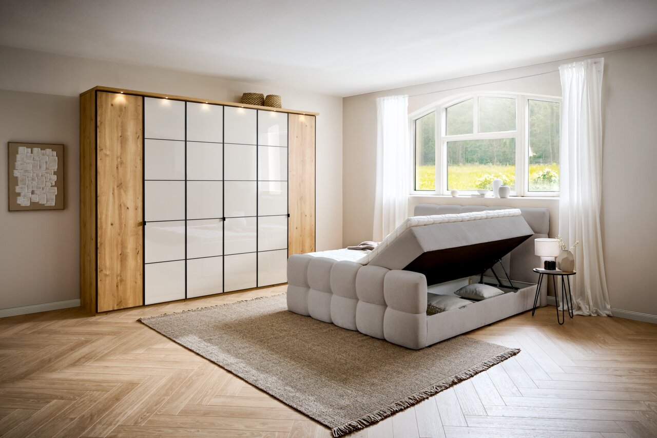 Boxbett mit Stauraum in einem hellen Schlafzimmer, seitliche Perspektive