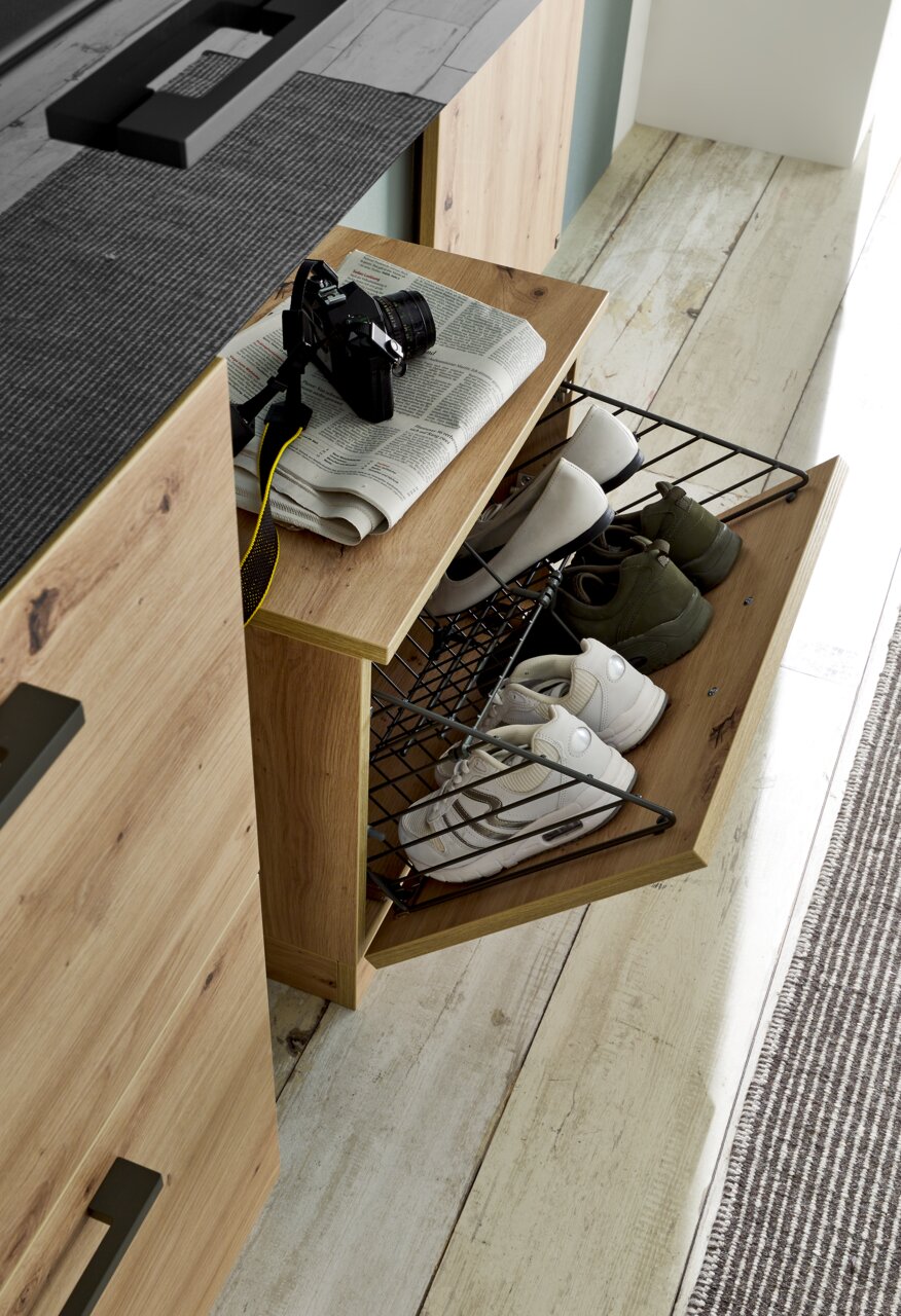 Schuhregal aus Holz mit ausziehbarem Gitterkorb, gefüllt mit Schuhen, von oben betrachtet.