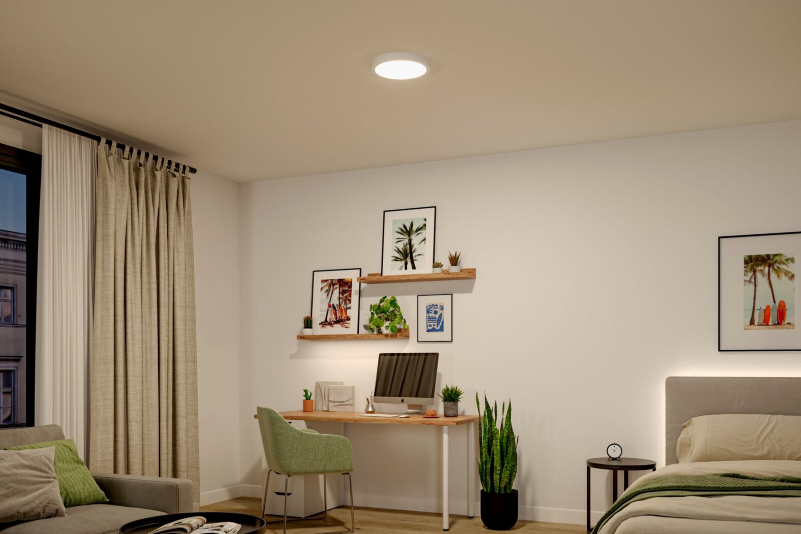Runde, flache LED-Deckenleuchte in Weiß, eingeschaltet und bündig an der Decke montiert, in einem modern eingerichteten Schlafzimmer/Homeoffice; Ansicht von unten in leichter Raum-Gesamtperspektive.