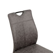 Detailansicht eines grauen Schwingstuhls mit gepolsterter Rückenlehne und schwarzem Griff.