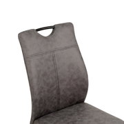 Detailfoto van een grijze schommelstoel met gestoffeerde rugleuning en zwarte handgreep.