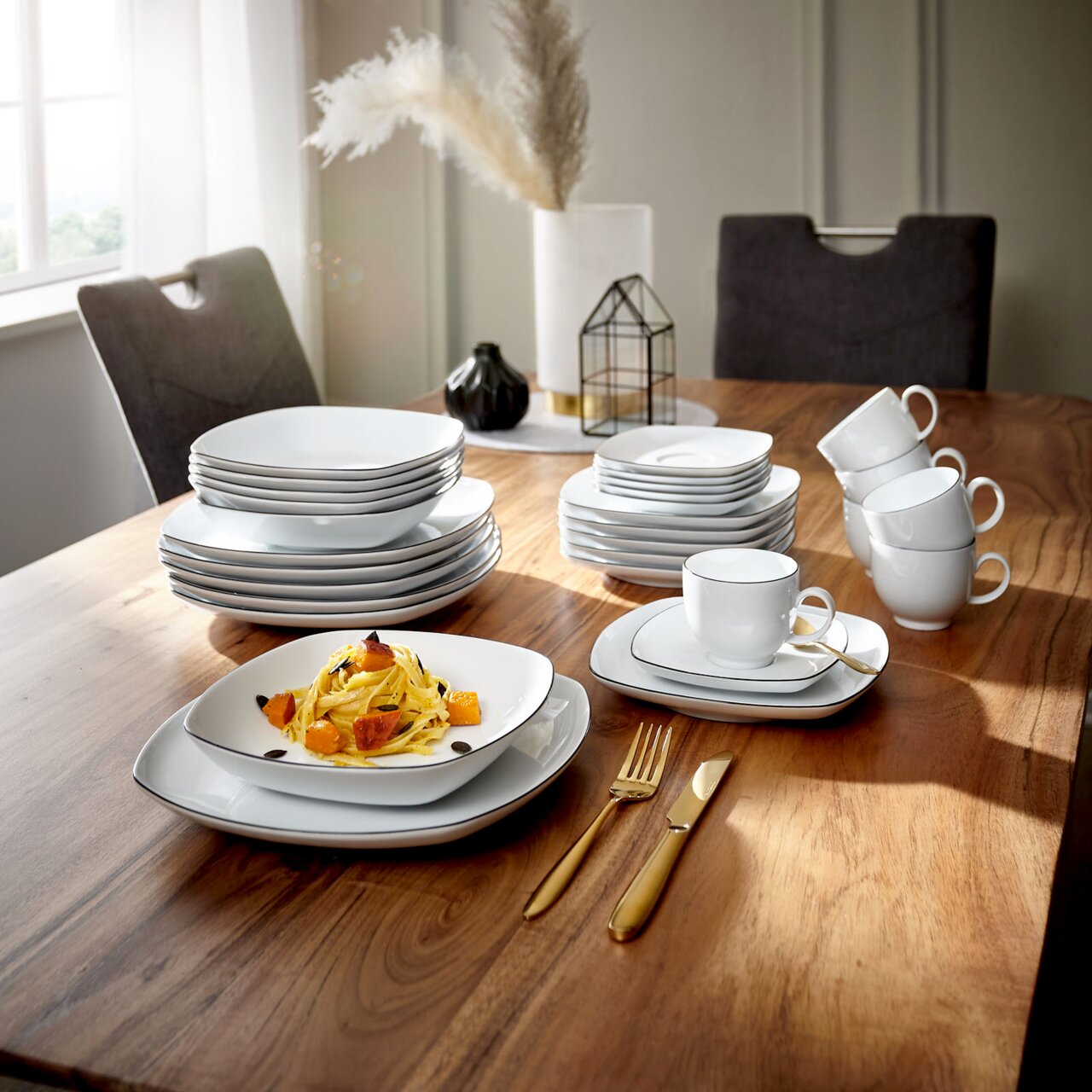 Elegantes Kombiservice Lido Black eckig auf einem Holztisch, bestehend aus Tellern, Tassen und Besteck, in einer stilvollen Tischdekoration von schräg oben betrachtet.