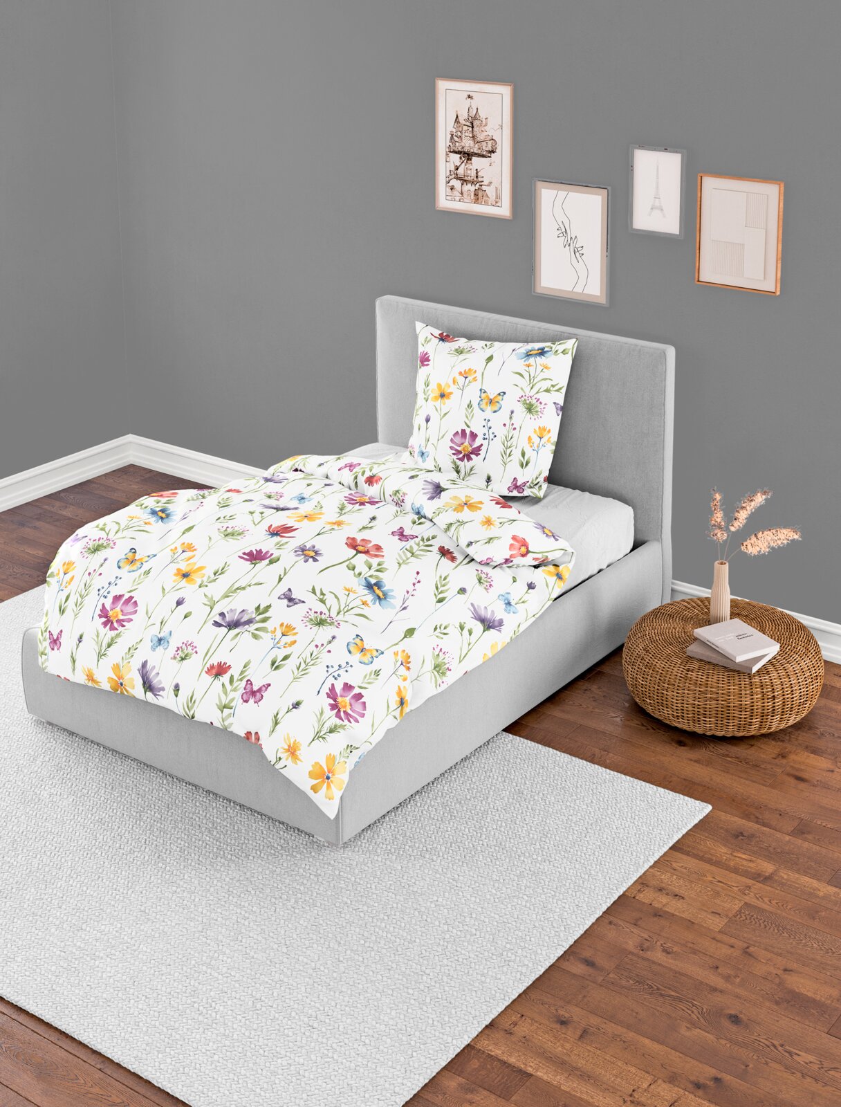 Bierbaum Bettwäsche Bettwäsche-Set 135x200cm mit buntem Blumenmuster auf einem grauen Bett, fotografiert aus der Vogelperspektive in einem modern eingerichteten Raum.