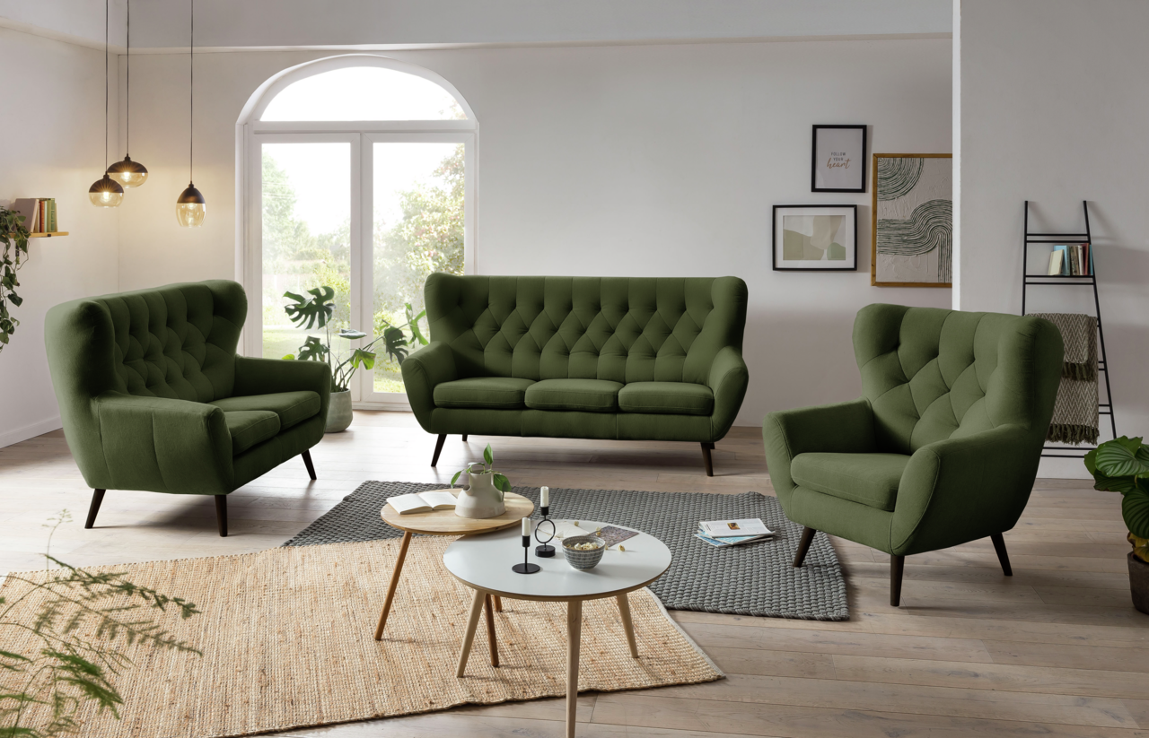 Grünes Sofa-Set bestehend aus einem 3-Sitzer, einem 2-Sitzer und einem Sessel in einem modernen Wohnzimmer mit Holzboden und großen Fenstern, seitliche Perspektive.