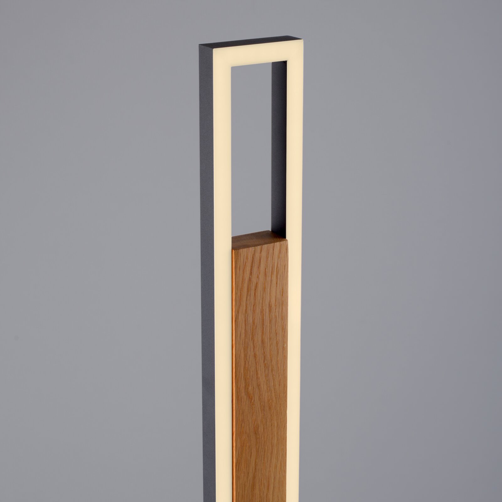 Moderne staande lamp met houten middenstuk en rechthoekig antraciet frame met warmwitte ledverlichting, gezien schuin van voren.