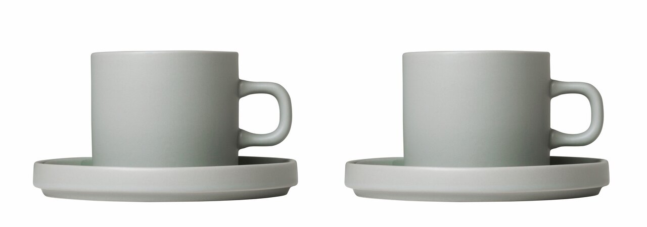 Zwei graue Kaffeetassen mit Untertassen, seitliche Ansicht.