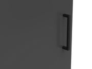 Nahaufnahme eines schwarzen Griffs an einer dunkelgrauen Kommodentür, seitliche Perspektive