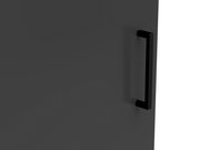 Nahaufnahme eines schwarzen Griffs an einer dunkelgrauen Kommodentür, seitliche Perspektive