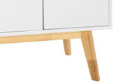 Nahaufnahme eines weißen Sideboards mit Holzbeinen, perspektivisch von der Seite aufgenommen.