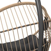 Nahaufnahme eines Hängesessels mit geflochtenem Seil und schwarzem Kissen, seitliche Perspektive