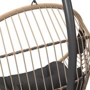 Nahaufnahme eines Hängesessels mit geflochtenem Seil und schwarzem Kissen, seitliche Perspektive