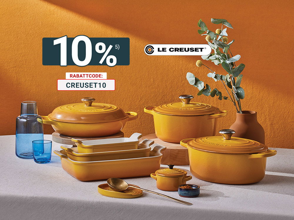 Le-Creuset Gusseisen-Töpfe und Auflaufformen in Gelb-Orange auf gedecktem Tisch