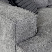 Close-up van een grijze hoekbank met een gestructureerde stoffen bekleding en een sierkussen, gezien van bovenaf.