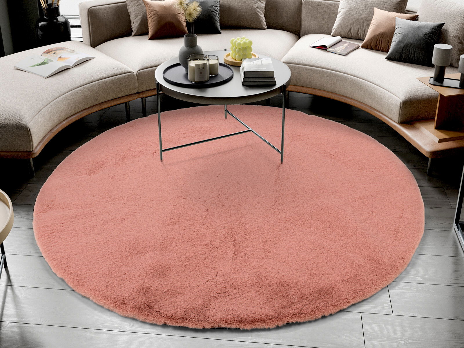 Runder, rosafarbener Fellteppich in einem modernen Wohnzimmer, von oben betrachtet, unter einem runden Couchtisch platziert.
