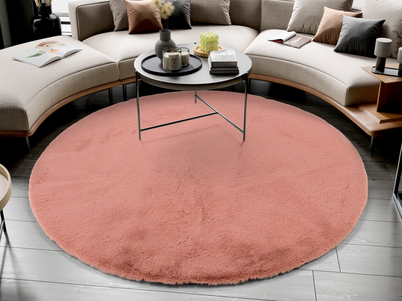 Runder, rosafarbener Fellteppich in einem modernen Wohnzimmer, von oben betrachtet, unter einem runden Couchtisch platziert.