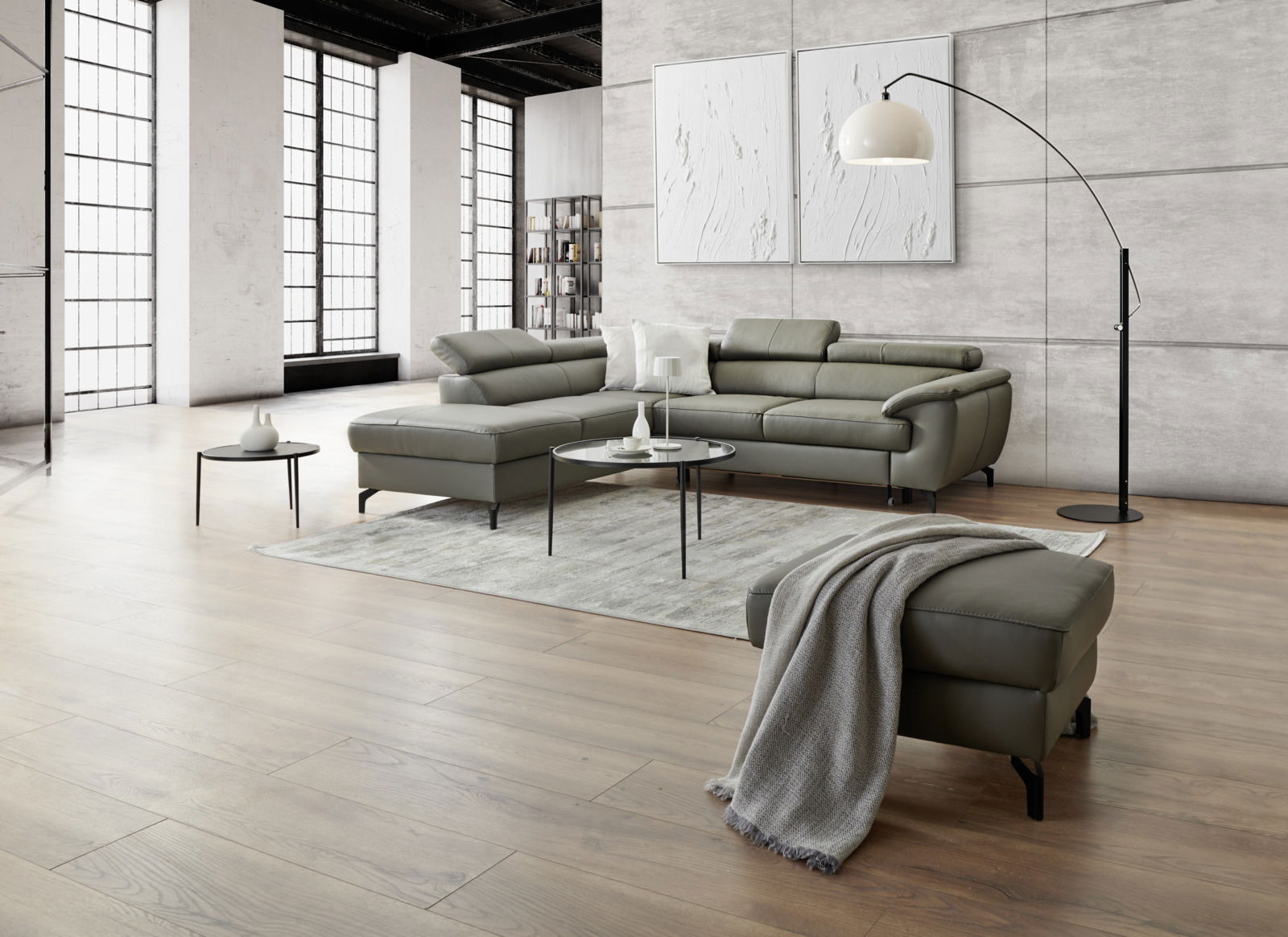 Moderne Eckgarnitur in einem hellen, stilvollen Wohnzimmer mit großen Fenstern und Holzboden, seitliche Perspektive.